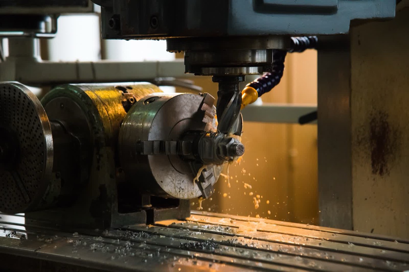 A milling machine cutting metal with coolant spraying