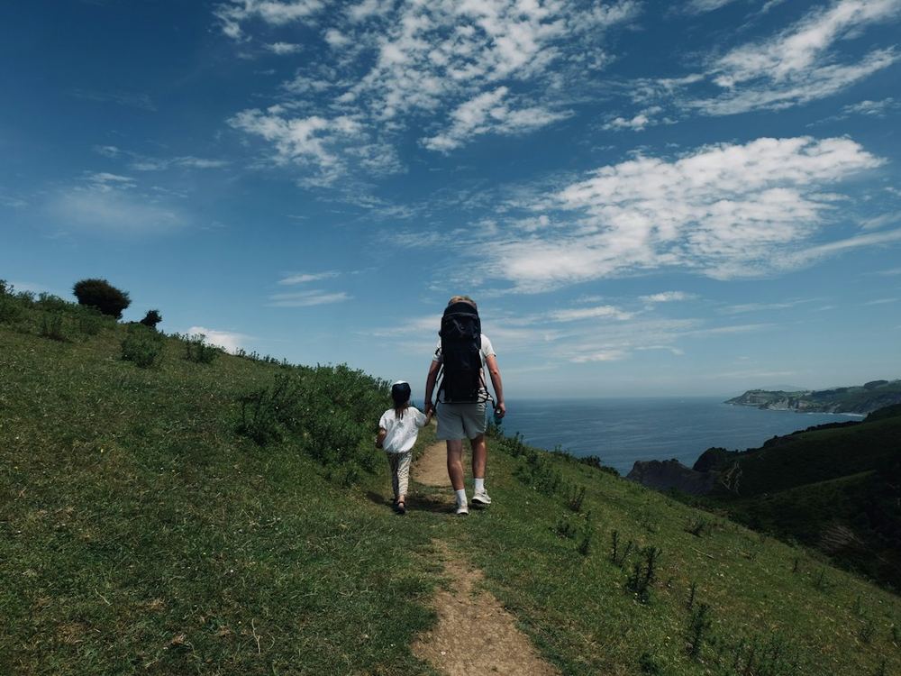 A hiker and child on a coastal trail
