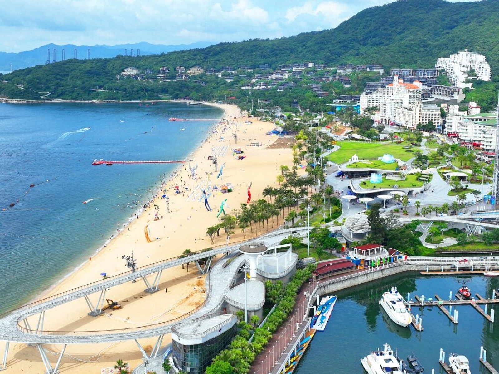 Aerial view of Dameisha beach in Shenzhen with the boardwalk, marina and green hills